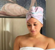 Woman wearing a mermaid pattern microfiber turbie twist, reading a book in bed